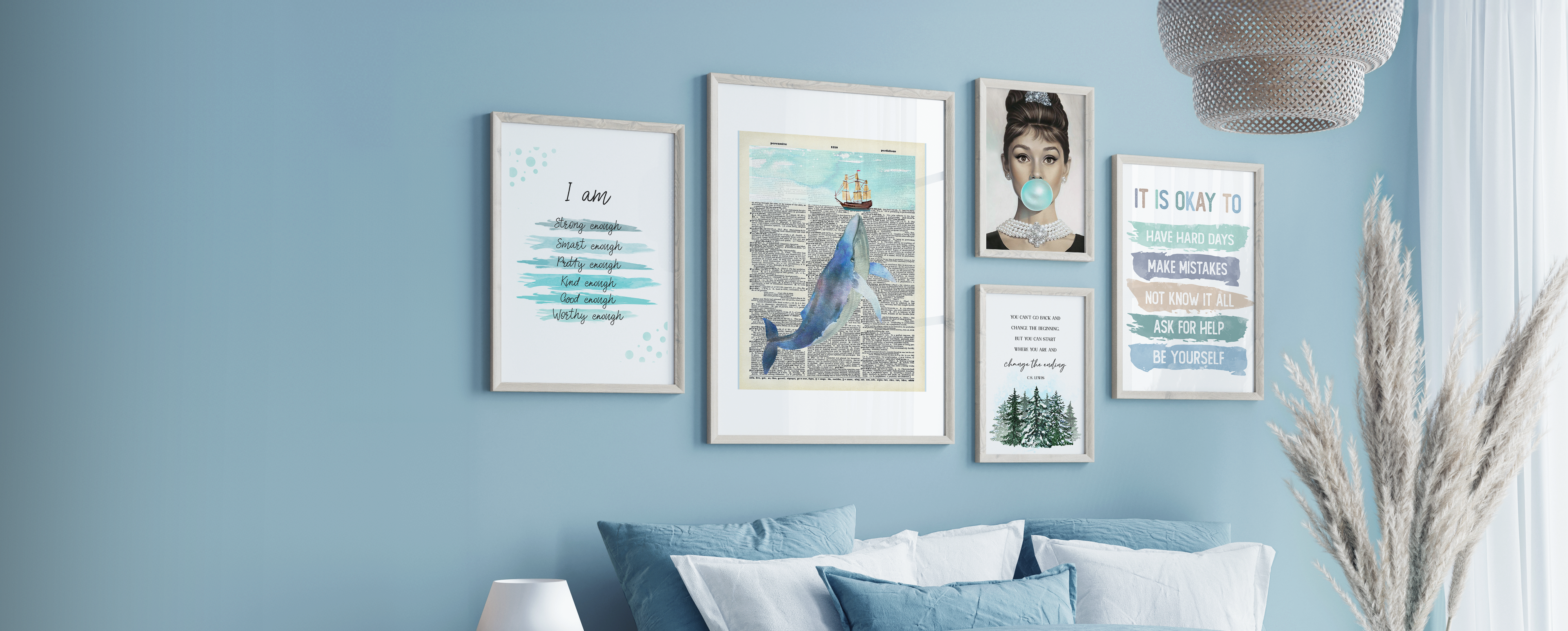 Five framed wall art prints on a blue wall above a bed